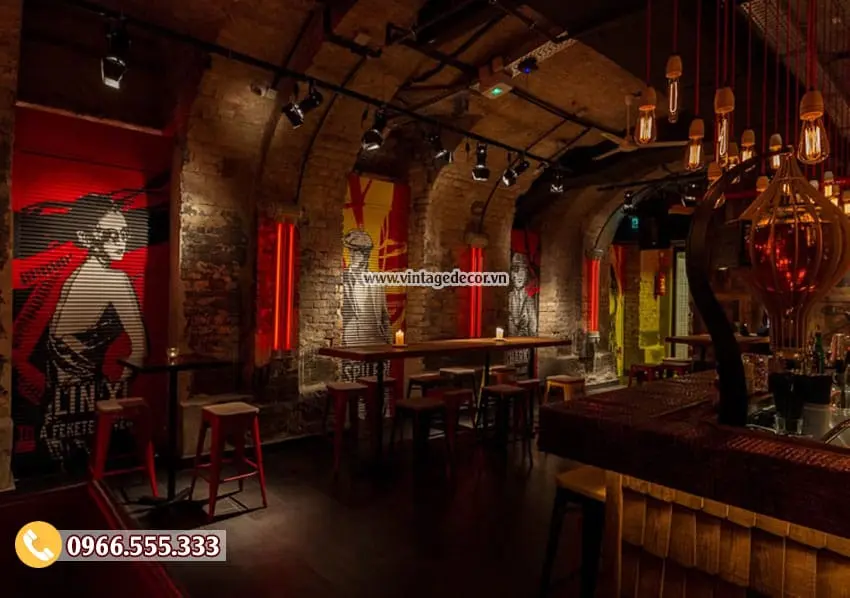 Góc khác của bar hầm vòm gạch, tranh tường người phụ nữ nền đỏ, đèn hình khinh khí cầu, bàn ghế cao