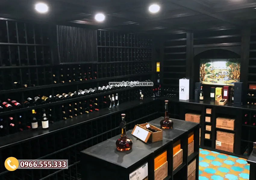 Hầm rượu kệ gỗ sơn đen kín vách, đảo đen giữa phòng bày bình rượu, sàn gạch bông xanh cam