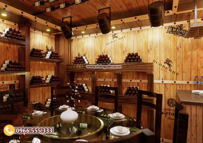Bàn tròn mâm kính xoay trong BR93, phía sau là kệ xếp tháp chai và tường ván in chữ