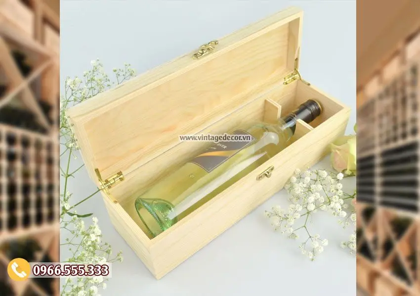 Hộp gỗ thông nằm ngang mở nắp bản lề, khoá cài kim loại, một chai vang trắng nằm trong, một vách ngăn nhỏ trong lòng hộp
