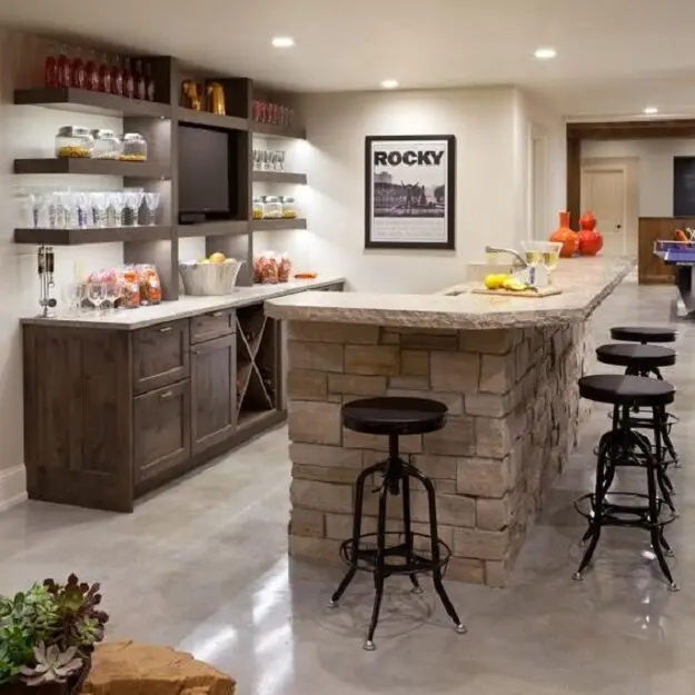 Phòng giải trí có quầy bar ốp đá, ghế cao chân sắt, phía sau là tủ gỗ và kệ treo tường bày ly