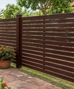 Hàng rào gỗ HR22 nâu cánh gián quanh sân gạch, chậu hoa đỏ dọc chân rào